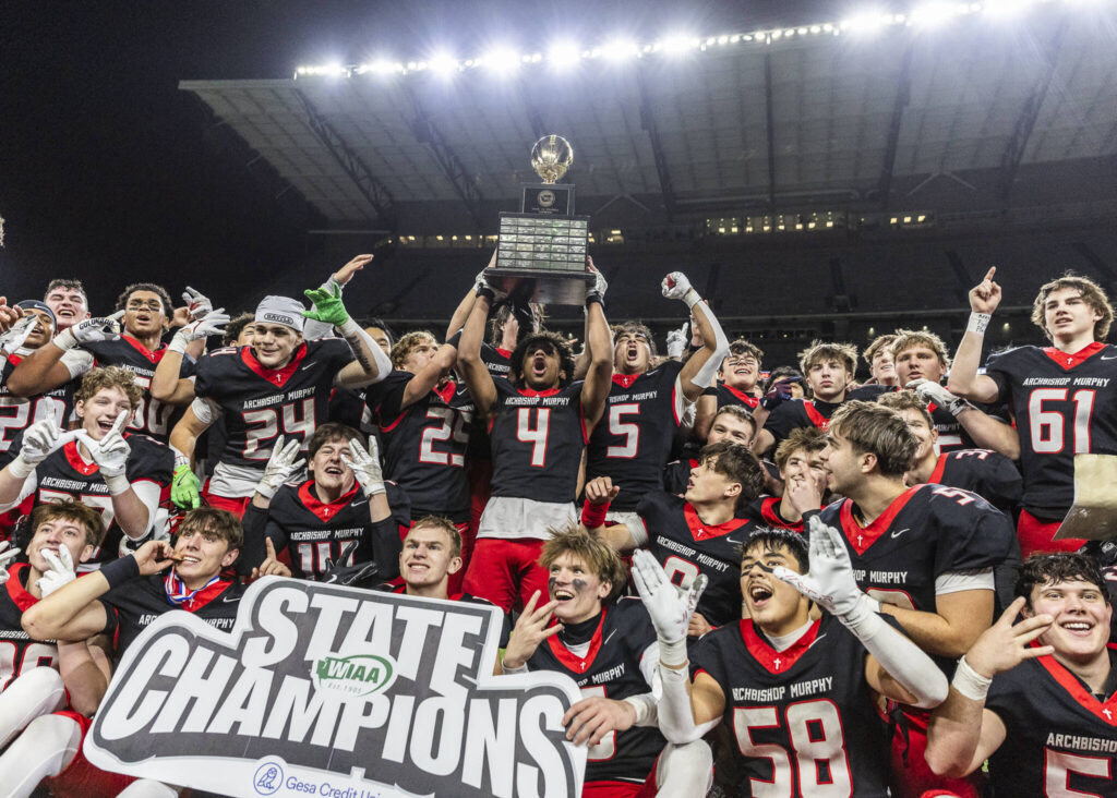 Archbishop Murphy holds up the 2A state championship trophy after beating Tumwater at Husky Stadium on Saturday, Dec. 6, 2025 in Seattle, Washington. (Olivia Vanni / The Herald)
