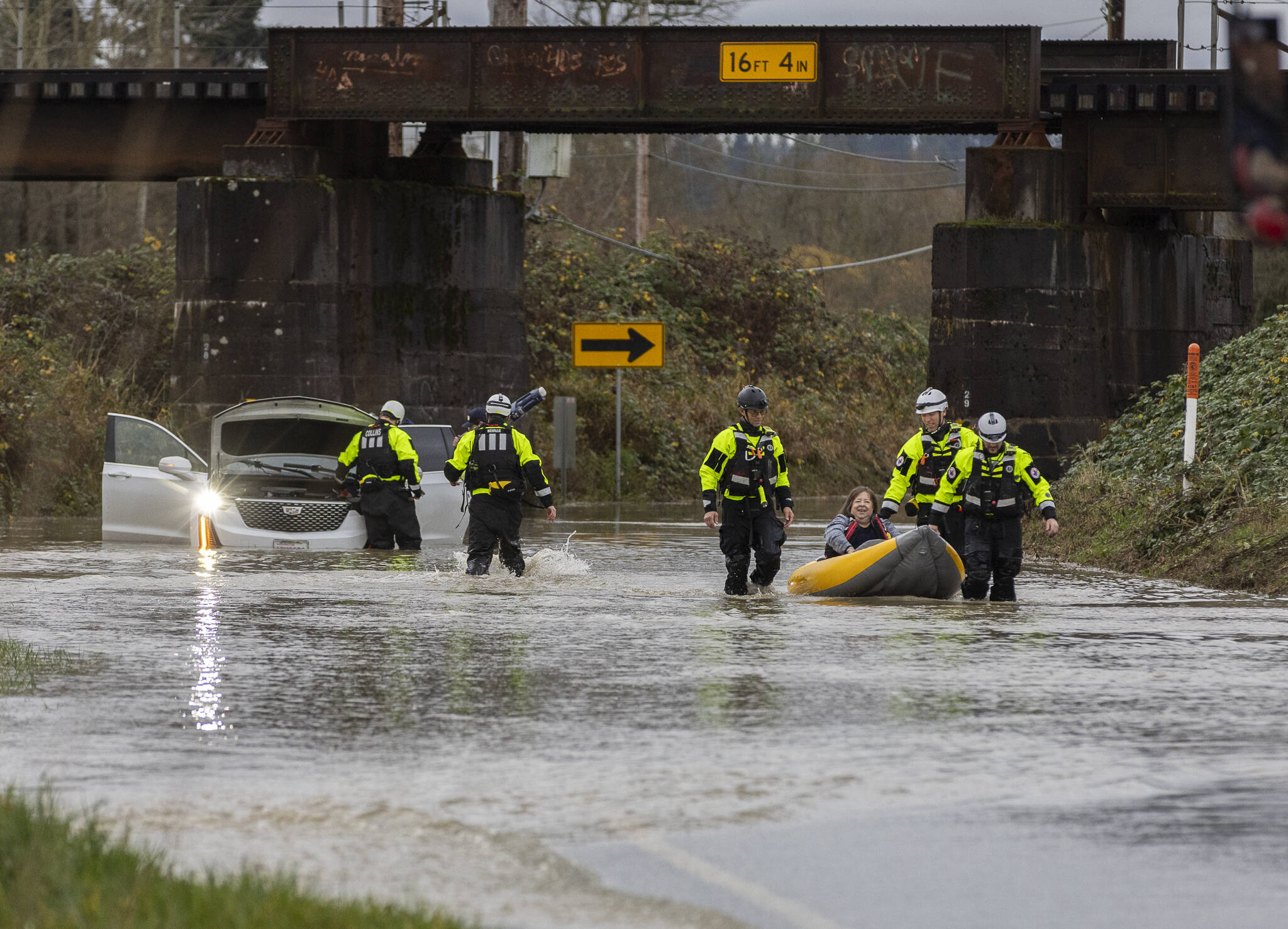 Snohomish Regional Fire & Rescue and Snohomish County Fire District 4 water units use an inflatable kayak to rescue occupants of a car stuck in floodwater covering a portion of Old Snohomish Monroe Road on Tuesday, Dec. 9, 2025 in Snohomish, Washington. (Olivia Vanni / The Herald)