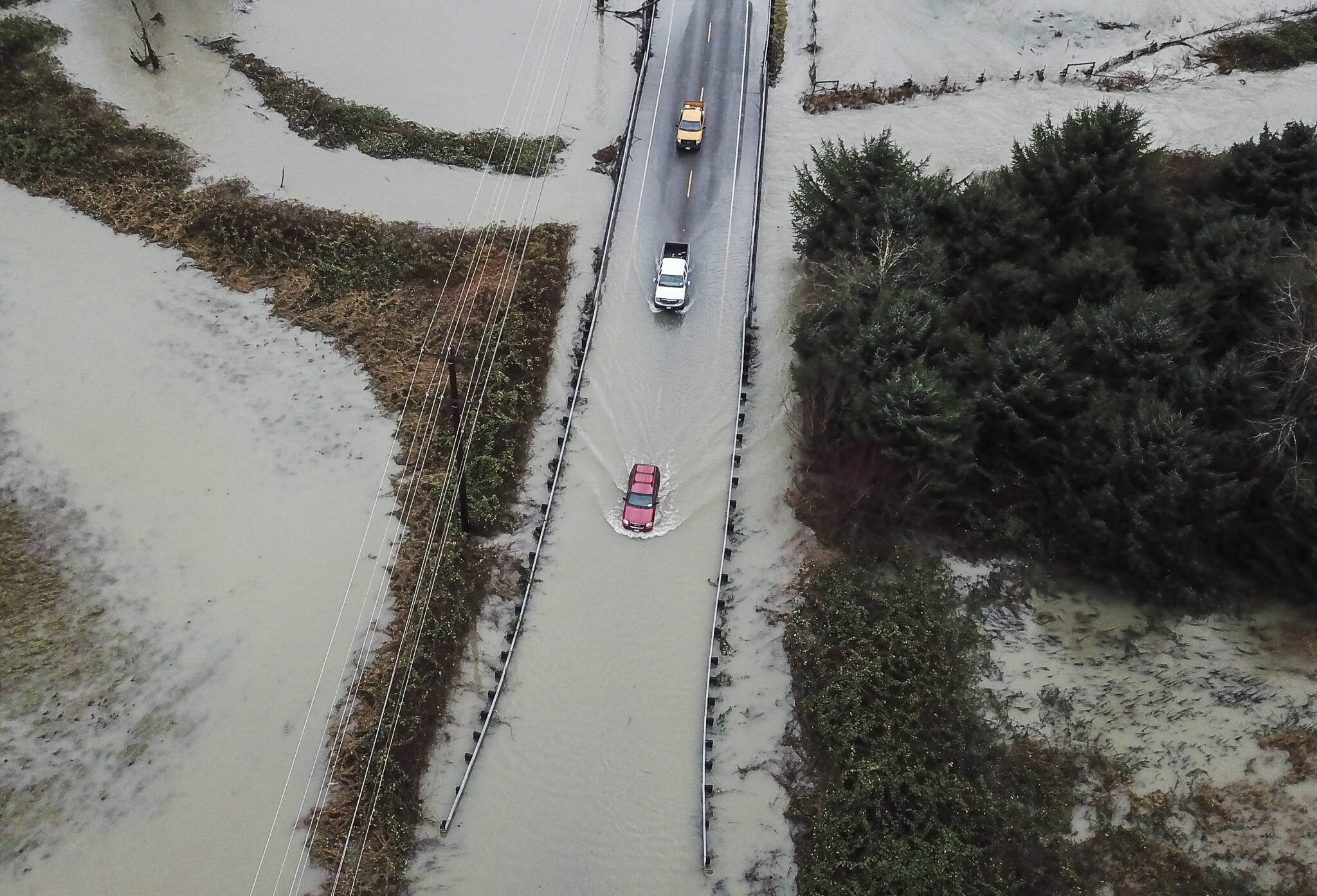 Drivers attempt to navigate floodwater from the Skykomish River covering Mann Road on Tuesday, Dec. 9, 2025 in Sultan, Washington. (Olivia Vanni / The Herald)