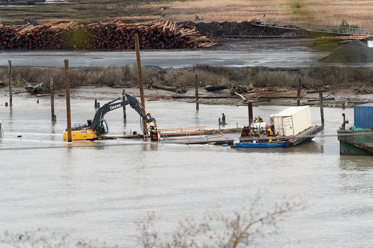 A barge sinks below water near Port Gardner Bay on Wednesday, Dec. 10 in Everett, Washington. (Will Geschke / The Herald)