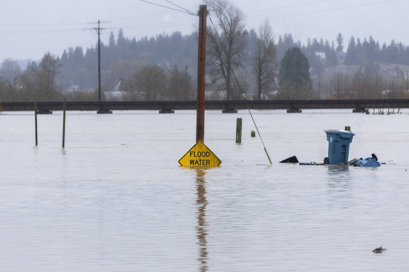 Floodwater from the Snohomish River partially covers a flood water sign along Lincoln Avenue on Thursday, Dec. 11, 2025 in Snohomish, Washington. (Olivia Vanni / The Herald)