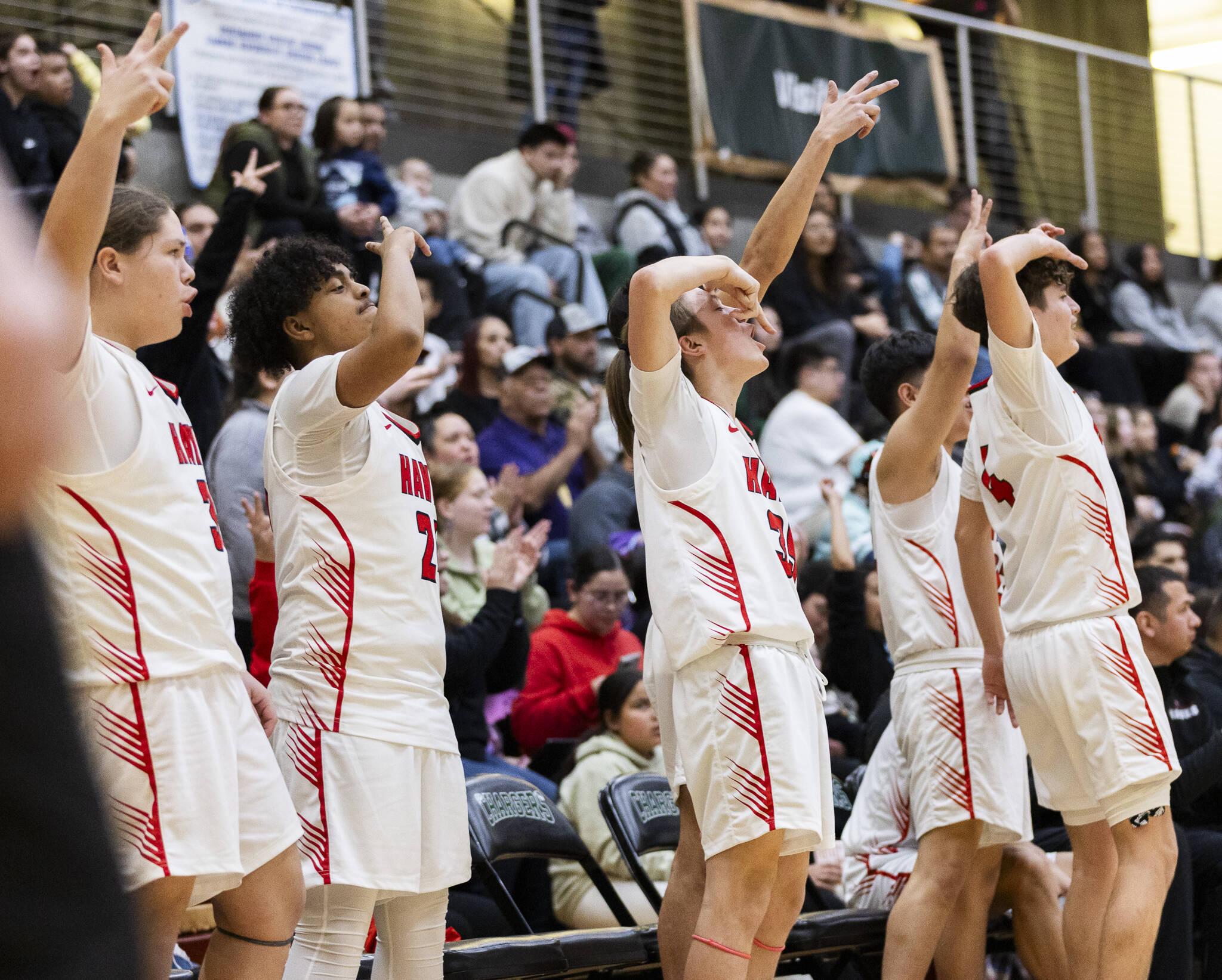 The Tulalip Heritage bench reacts to a 3-point shot during the winner-to-state playoff game against Muckleshoot Tribal School on Tuesday, Feb. 18, 2025 in Marysville, Washington. (Olivia Vanni / The Herald)