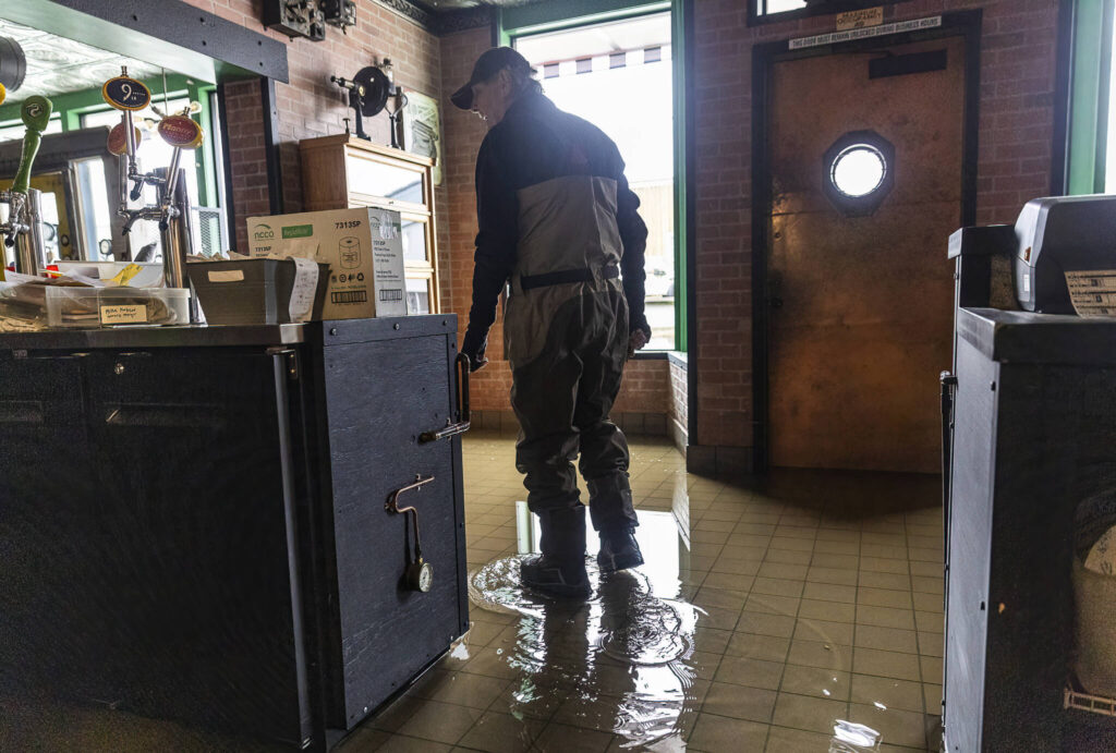 Bob Hammond, an employee at Red Pepper Pizzeria & Pasta, surveys the water damage inside of the restaurant due to flooding from the Skykomish River on Thursday, Dec. 11, 2025 in Sultan, Washington. (Olivia Vanni / The Herald)
