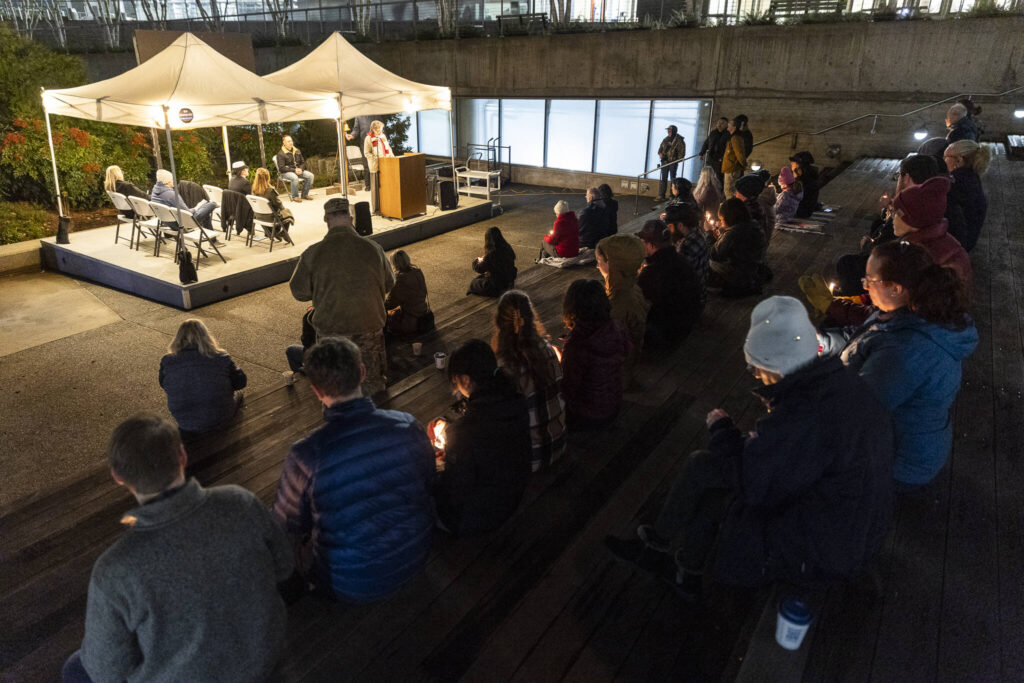 People holds candles while names of those that have died are read during the Snohomish County&rsquo;s Veterans Homelessness Committee&rsquo;s annual Homeless Memorial Vigil on Friday, Dec. 19, 2025 in Everett, Washington. (Olivia Vanni / The Herald)
