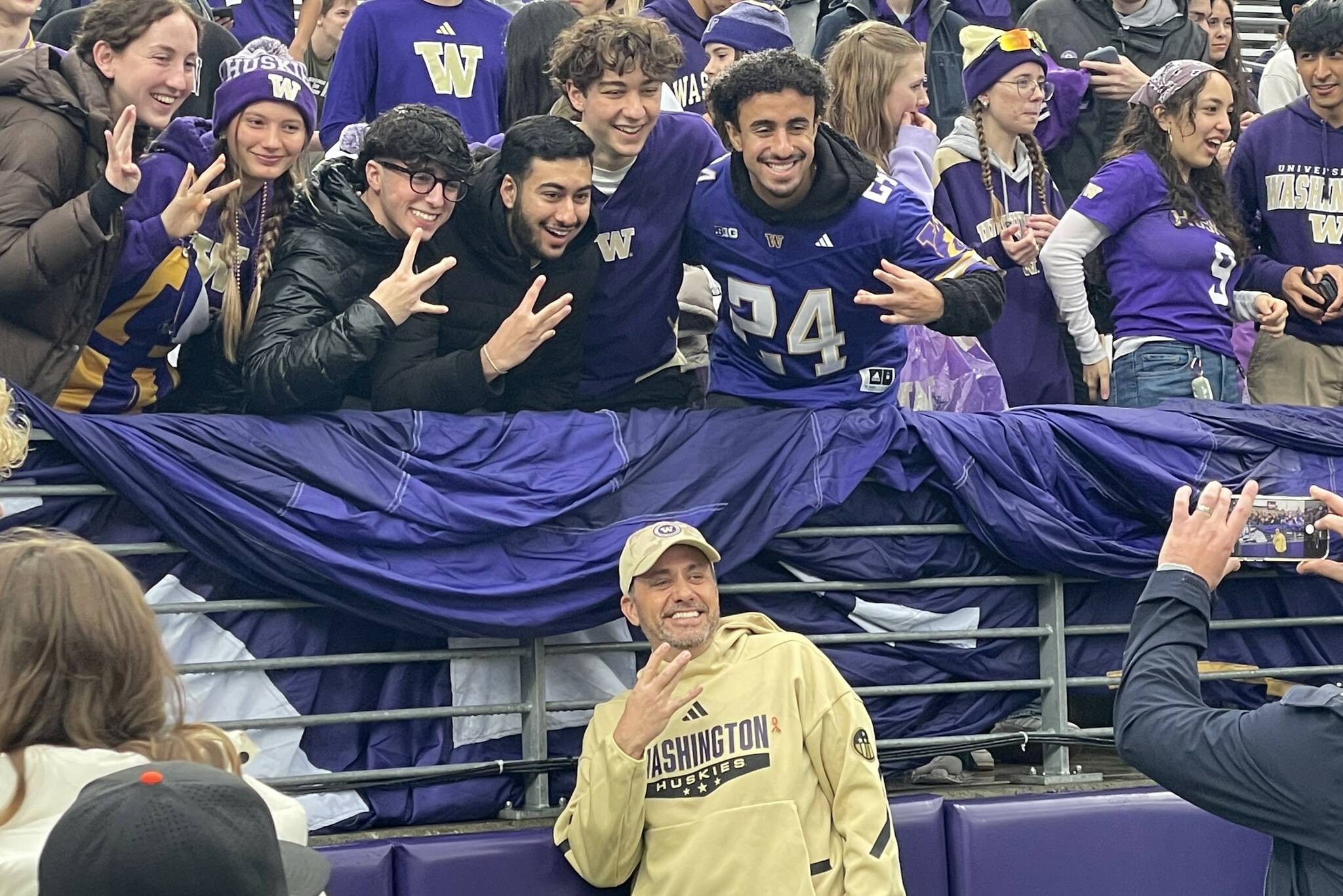 Huskies head football coach Jedd Fisch poses with members of the Washington Dawg Pack student section prior to a game against Purdue on Nov. 15, 2025 at Husky Stadium in Seattle, Washington. (Aaron Coe / The Herald)