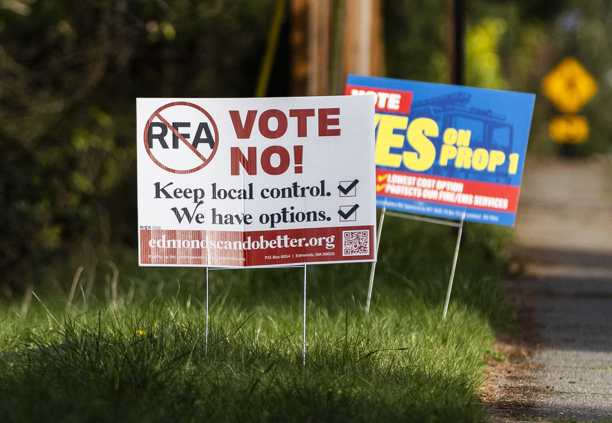 Signs in support of and in opposition of the Proposition 1 annexation into RFA are visible along 100th Avenue West on Thursday, April 3, 2025, in Edmonds, Washington. In April, voters approved annexation into South County Fire. As a result, the median homeowner will see property taxes increase by about $65 per month, or $780 per year.(Olivia Vanni / The Herald)