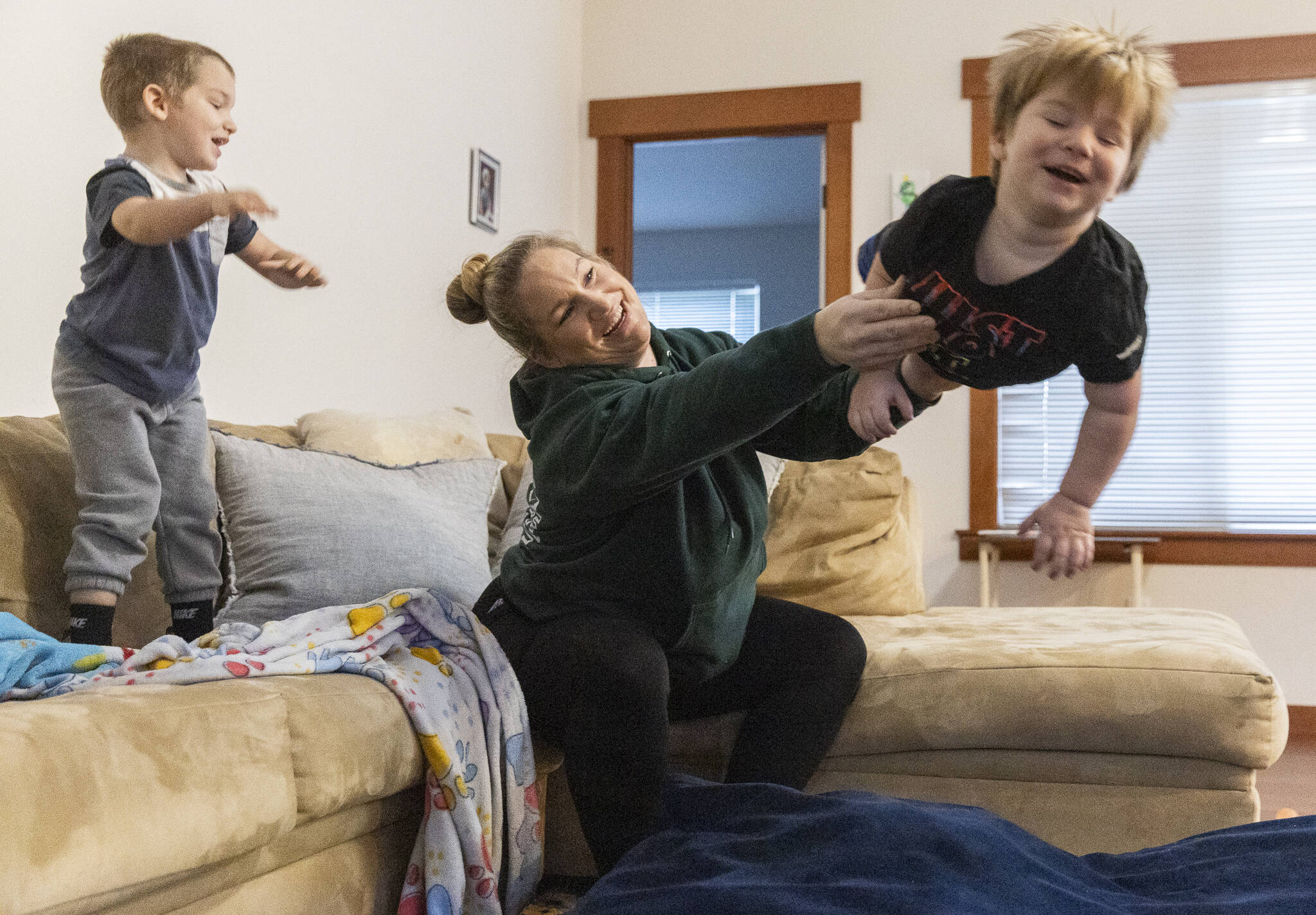 Stephanie Boyle tosses Oaklen, 2, onto a padded mat before getting her sons ready for daycare on Tuesday, Dec. 30, 2025 in Marysville, Washington. (Olivia Vanni / The Herald)