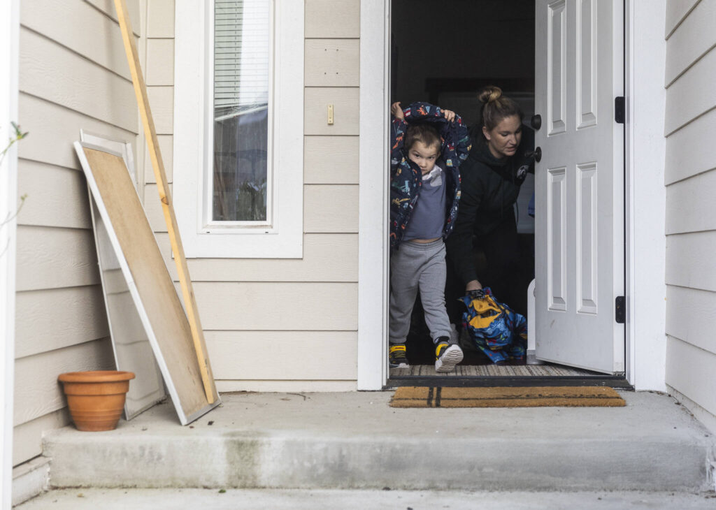 Raiden, 4, puts his jacket on and walks out the front door on Tuesday, Dec. 30, 2025 in Marysville, Washington. (Olivia Vanni / The Herald)
