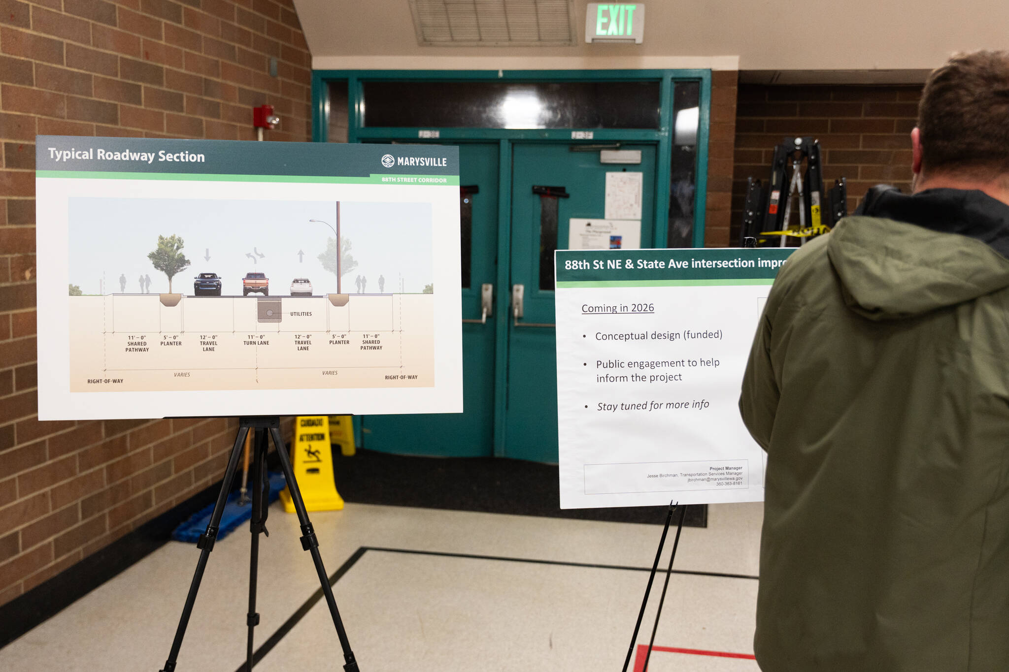 Attendees look at boards showing the proposed roadway design of the 88th Street improvements during a town hall on Tuesday in Marysville. (Will Geschke / The Herald)