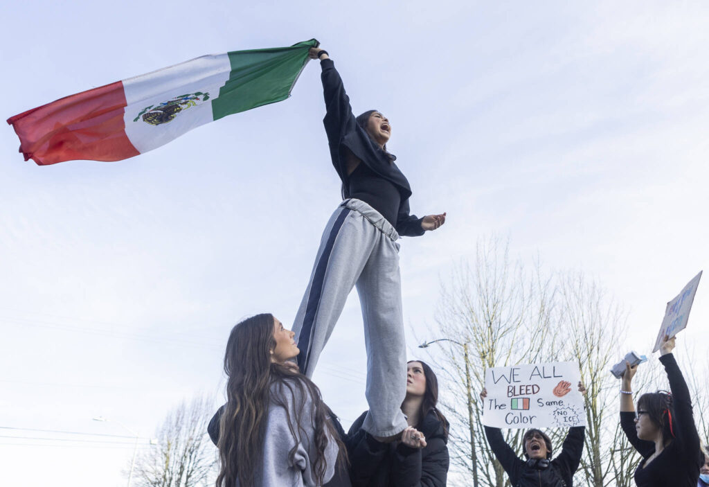 Venecia Cruz, a senior at Everett High School, yells and waves a Mexican flag during a walkout rally in protest of ICE outside of the Snohomish County Courthouse on Tuesday, Jan. 13, 2026, in Everett, Washington. (Olivia Vanni / The Herald)
