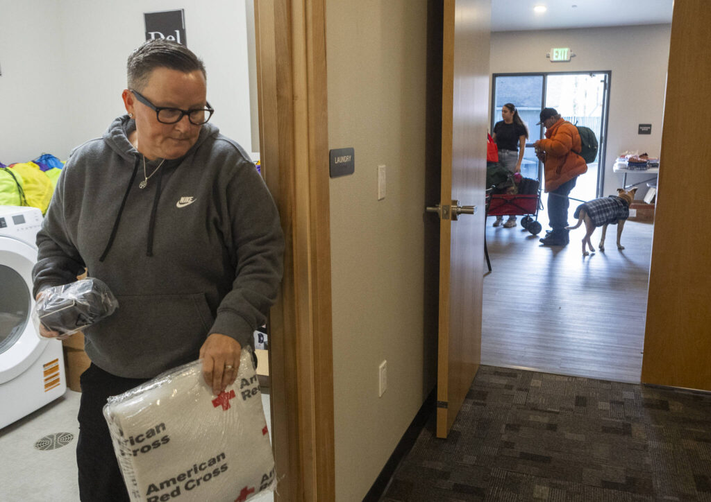 Tina Mandella, the operations director for Family Resource Centers, grabs a car bag for Bill Green at the Sky Valley Community Resource Center on Wednesday, Jan. 14, 2026 in Sultan, Washington. (Olivia Vanni / The Herald)
