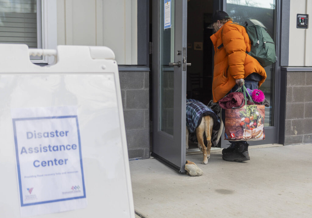Bill Green walks into the Disaster Assistance Center with his dog Malaki on Wednesday, Jan. 14, 2026 in Sultan, Washington. (Olivia Vanni / The Herald)
