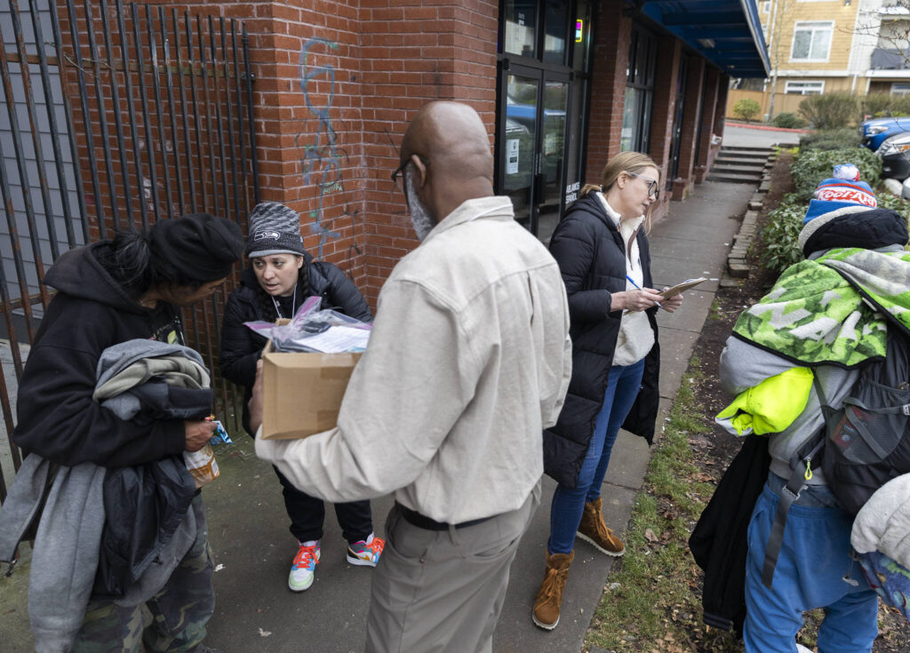 Rachel McGee, Toni Gardner and Jobe Momodou ask individuals questions for the Point In Time count survey on Tuesday, Jan. 27, 2026, in Everett, Washington. (Olivia Vanni / The Herald)
