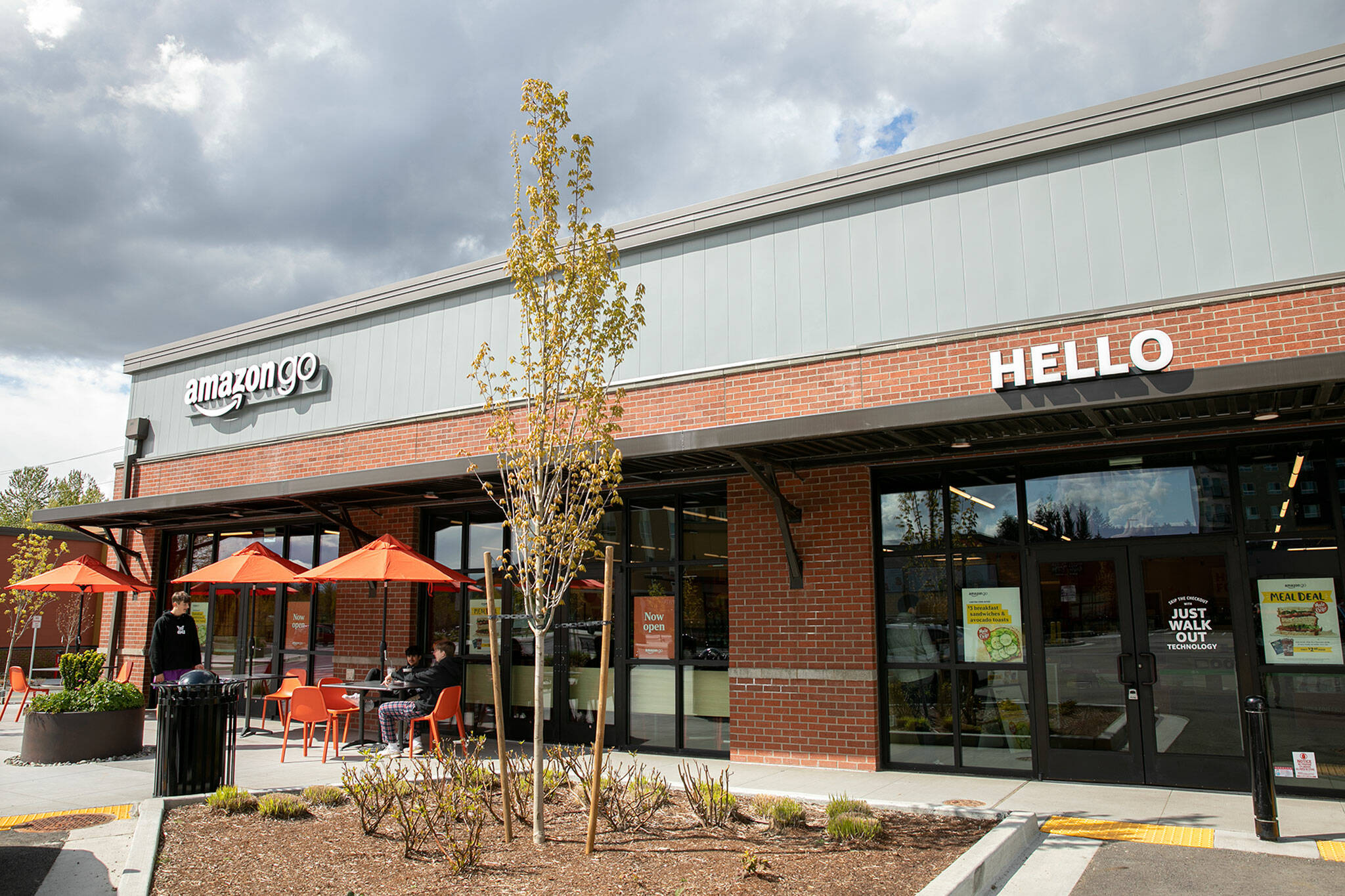 People sit outside the recently opened Amazon Go facility Wednesday, April 27, 2022, in Mill Creek, Washington. (Ryan Berry / The Herald)