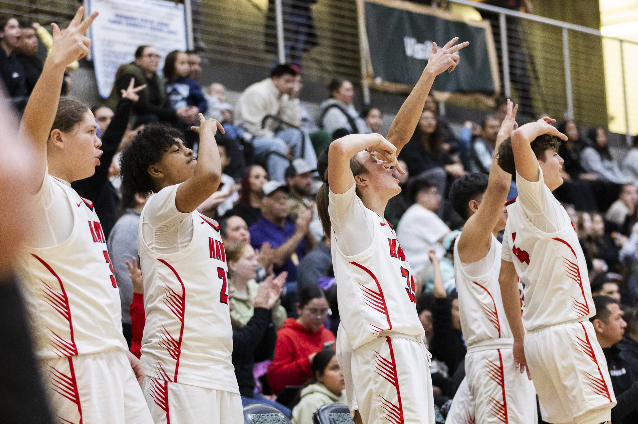 The Tulalip Heritage bench reacts to a 3-point shot during the winner-to-state playoff game against Muckleshoot Tribal School on Tuesday, Feb. 18, 2025 in Marysville, Washington. (Olivia Vanni / The Herald)