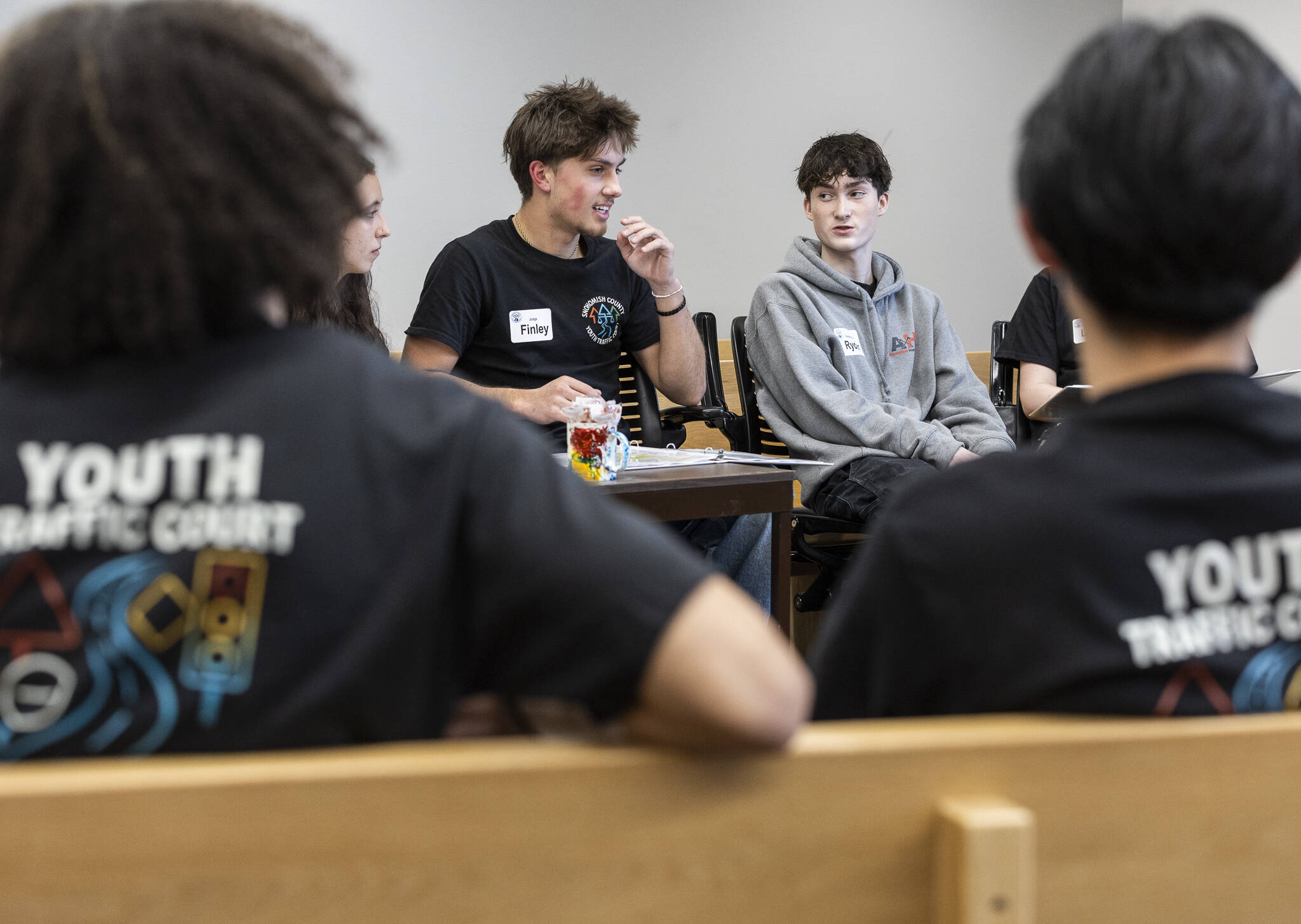 Finley Howard, the judge for the Youth Traffic Court session, talks with respondent Ryder Anderson at the Snohomish County Courthouse on Friday, Jan. 30, 2026 in Everett, Washington. (Olivia Vanni / The Herald)