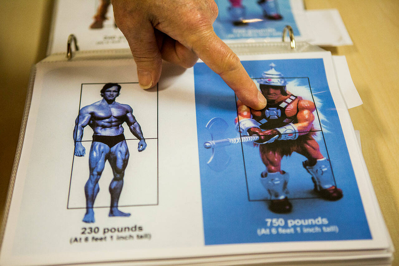 Roger Sweet shows the plans for the He-Man figurine in an information binder at BobaKhan Toys & Collectibles on Friday, April 12, 2019 in Everett, Wash. (Olivia Vanni / The Herald)