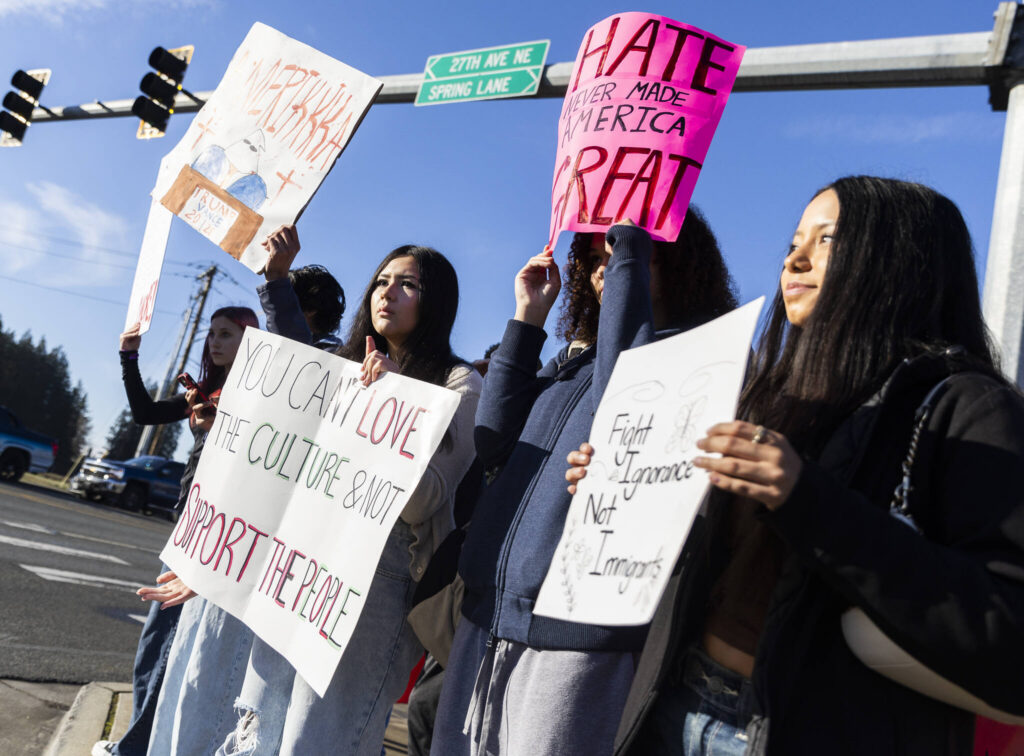 Alia Hueso, left to right, Asha Fofana, and Analia Castillo, sophomores at Lakewood High School, hold signs during a student walkout and protest on Thursday, Feb. 5, 2026 in Marysville, Washington. (Olivia Vanni / The Herald)
