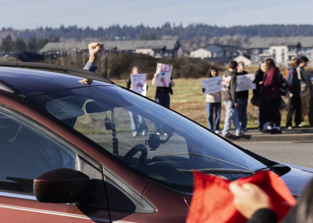 A driver puts a fist in the air while driving past a student walkout and protest on Thursday, Feb. 5, 2026 in Marysville, Washington. (Olivia Vanni / The Herald)
