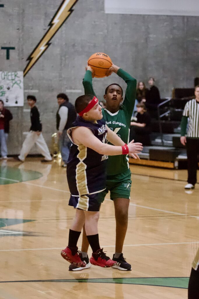 Marysville Getchell&rsquo;s Eyobed Angelo heaves up a shot from behind the 3-point arc over Arlington&rsquo;s Conner Cohee during the Chargers unified basketball game against the Eagles at Marysville Getchell High School on Feb 9, 2026. (Joe Pohoryles/The Herald)
