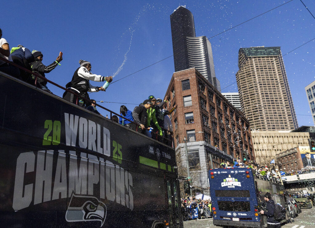 A Seahawks player sprays the crowd with champagne during the Seahawks World Champions Parade on Wednesday, Feb. 11, 2026 in Seattle, Washington. (Olivia Vanni / The Herald)
