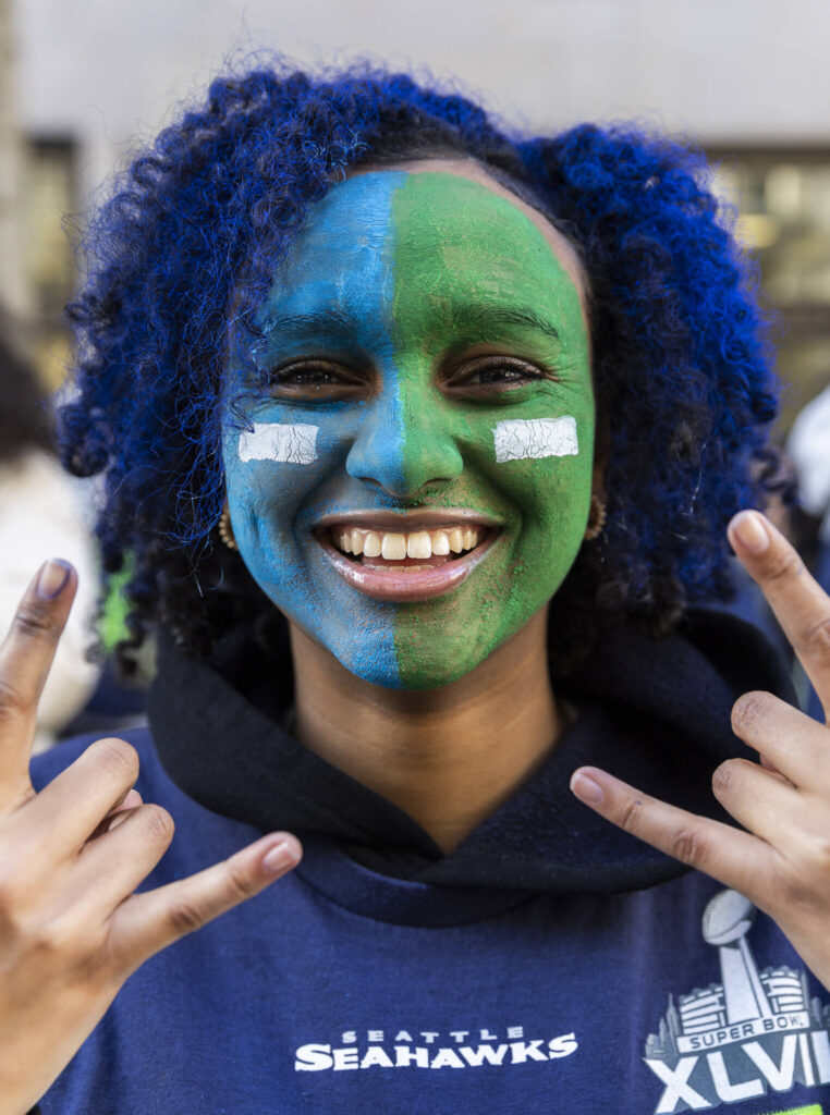 Sesen Kiflom smiles while wearing Seahawk colored faceprint during the Seahawks World Champions Parade on Wednesday, Feb. 11, 2026 in Seattle, Washington. (Olivia Vanni / The Herald)

