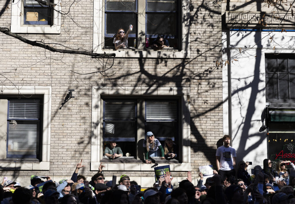 People cheer from windows during the Seahawks World Champions Parade on Wednesday, Feb. 11, 2026, in Seattle, Washington. (Olivia Vanni / The Herald)
