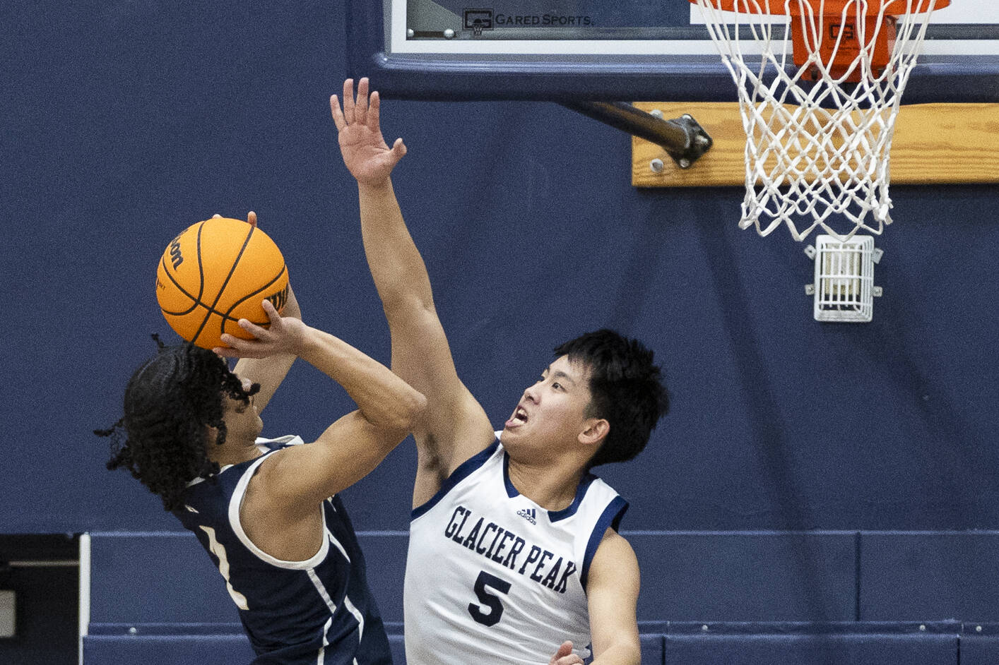 Glacier Peak’s Edison Kan blocks a shot by Arlington’s Mac Crews during the game on Friday, Jan. 16, 2026 in Snohomish, Washington. (Olivia Vanni / The Herald)