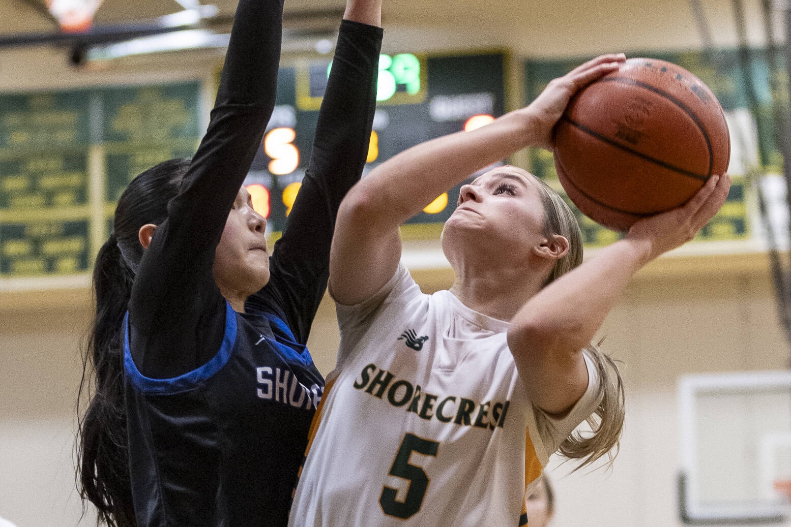 Shorewood’s Maya Glasser reaches up to try and block a layup by Shorecrest’s Anna Usitalo during the 3A district playoff game on Friday, Feb. 14, 2025 in Shoreline, Washington. (Olivia Vanni / The Herald)