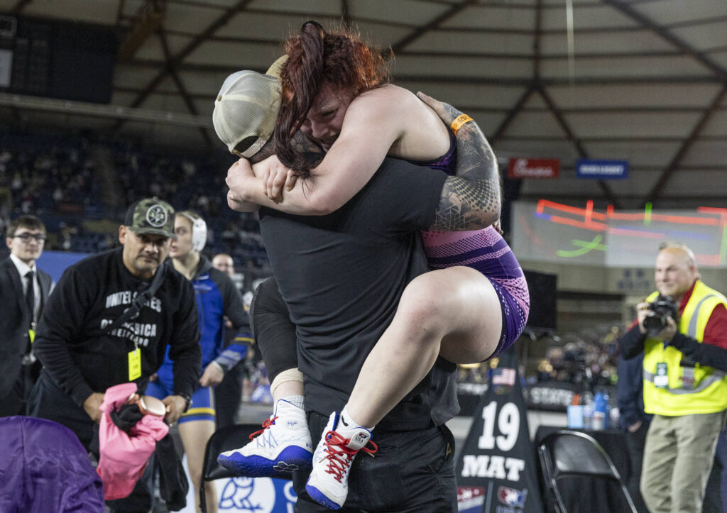 Lake Stevens&rsquo; Jillian Hradec hugs her coach after winning the 4A girls 155-pound championship match at the Mat Classic on Friday, Feb. 20, 2026 in Tacoma, Washington. (Olivia Vanni / The Herald)
