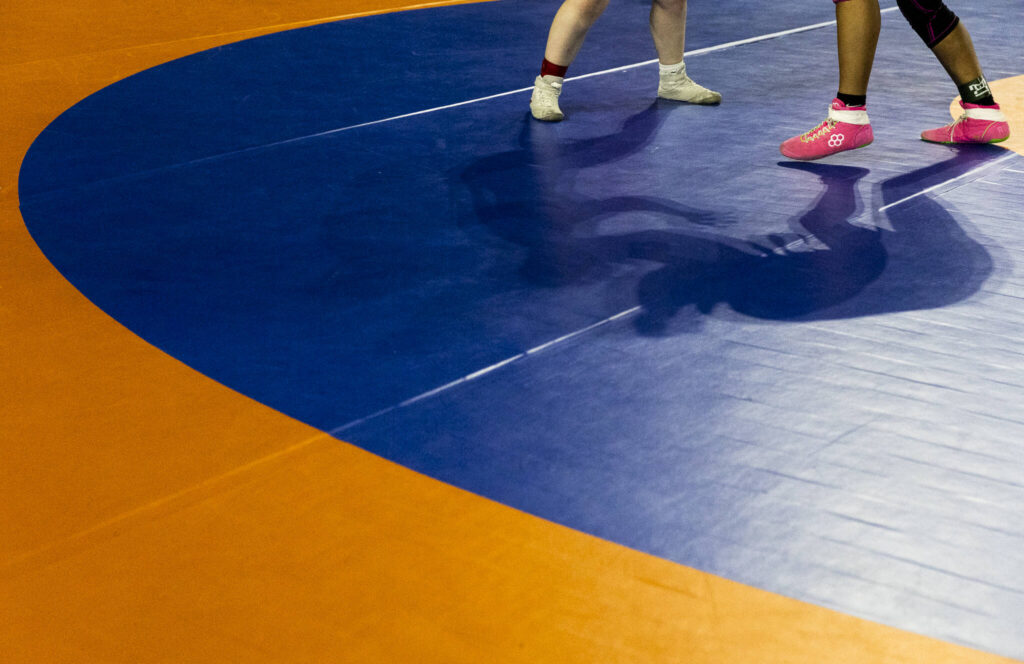 Wrestlers cast shadows during a match at the Mat Classic on Friday, Feb. 20, 2026 in Tacoma, Washington. (Olivia Vanni / The Herald)
