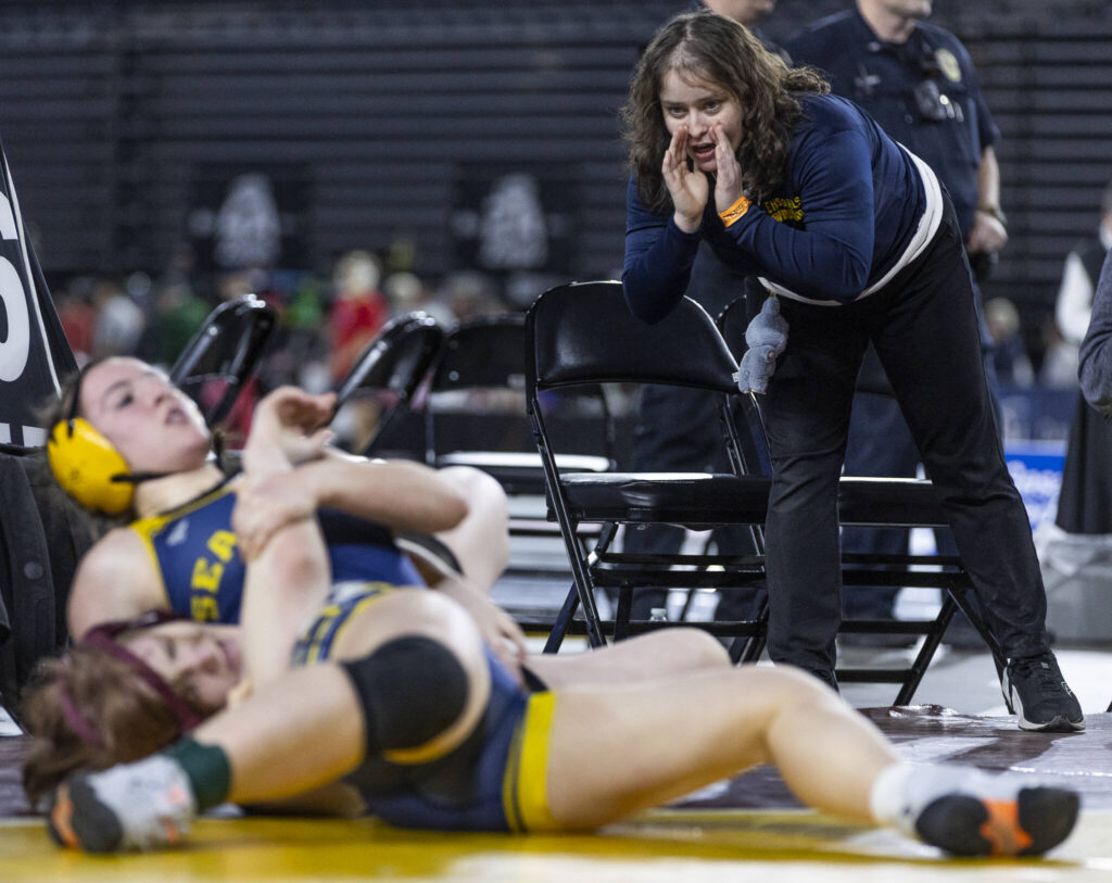 An Everett coach yells instructions to Everett&rsquo;s Caitriona Wieber during the 3A girls 155-pound semifinal match at the Mat Classic on Friday, Feb. 20, 2026 in Tacoma, Washington. (Olivia Vanni / The Herald)
