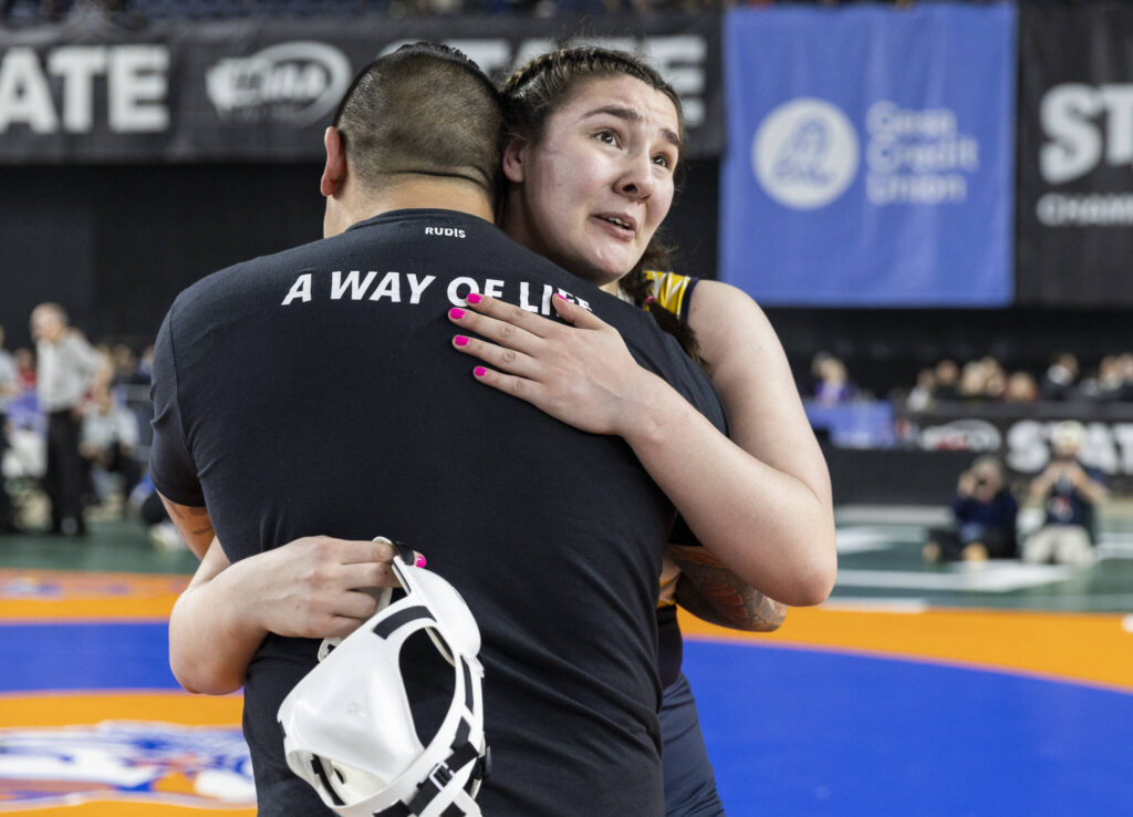 Everett&rsquo;s Mia Cienega hugs her coach after winning the 3A girls 235-pound championship match at the Mat Classic on Friday, Feb. 20, 2026 in Tacoma, Washington. (Olivia Vanni / The Herald)
