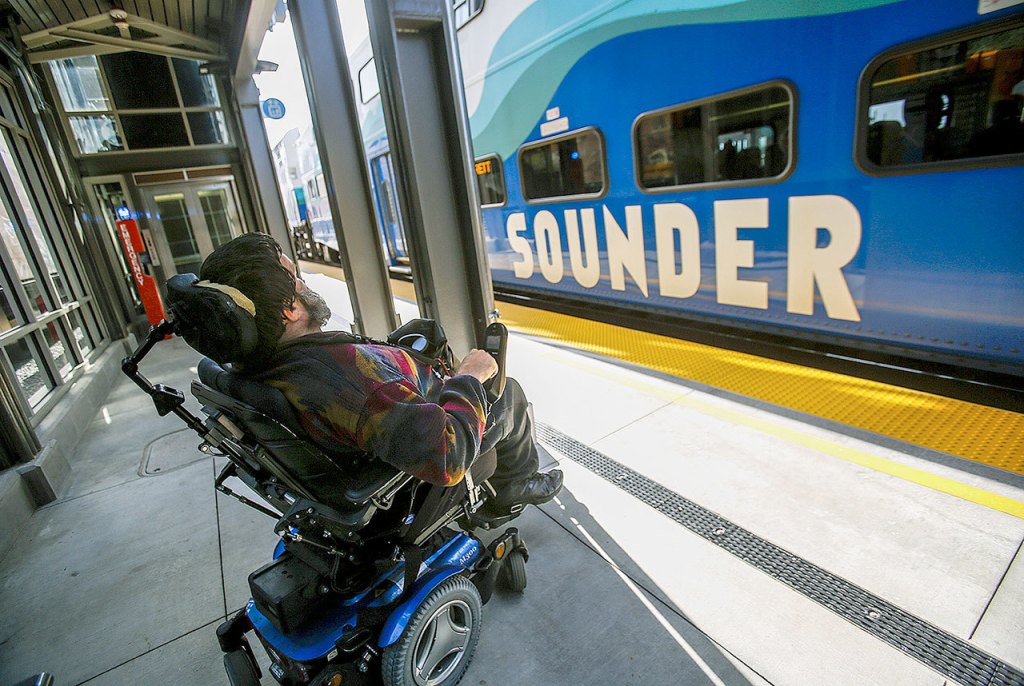 At the Mukilteo Station, Kent McDaniel watches as the Sounder pulls into the northbound passenger loading dock, which is on the opposite side of the tracks from the main one and parking lot. Previously McDaniel missed a lot of trains due to not knowing which track they were stopping at prior to their arrival, and him being unable to cross over in time in his wheelchair. (Dan Bates / The Herald)