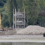 The pedestrian bridge at Howarth Park in Everett is seen as an excavator works Tuesday. (Ian Terry / The Herald)