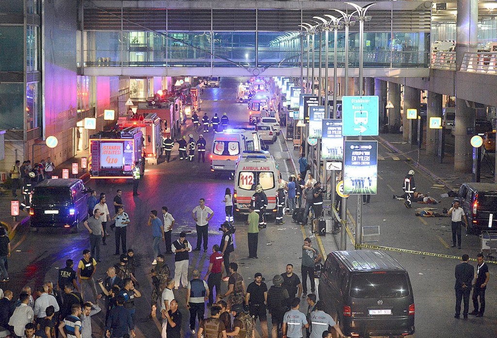 Medics and security members work at the entrance of the Ataturk Airport after explosions in Istanbulf on Tuesday. (IHA via Associated Press)