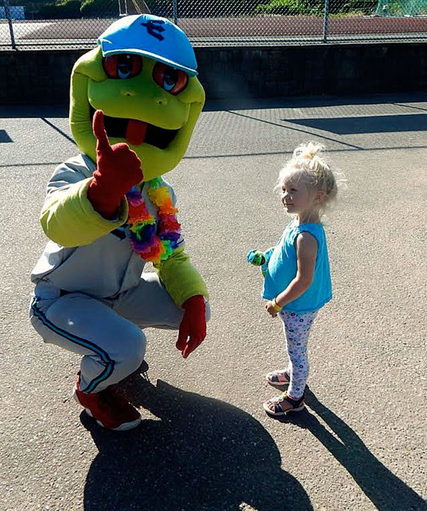 Paige Snitily, 2 1/2, of Edmonds, visits with the mascot Webbley at a recent AquaSox game in Everett. (Jon Bauer / The Herald)