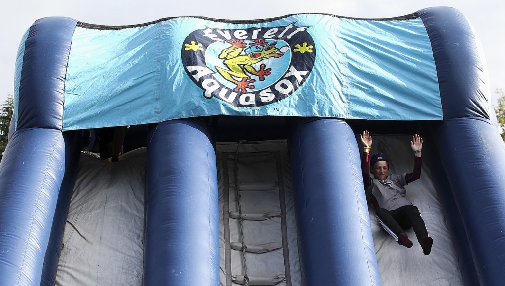 Inflatable slides in the Fun Zone provide entertainment during an AquaSox game at Everett Memorial Stadium. (Ian Terry / The Herald)