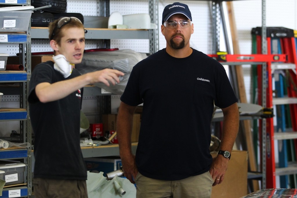 Weyauwega-Fremont High School teacher Mike Hansen talks with Glasair Aviation&rsquo;s Dan Holtz at the company&rsquo;s manufacturing facility in Arlington on June 22. (Ian Terry / The Herald)