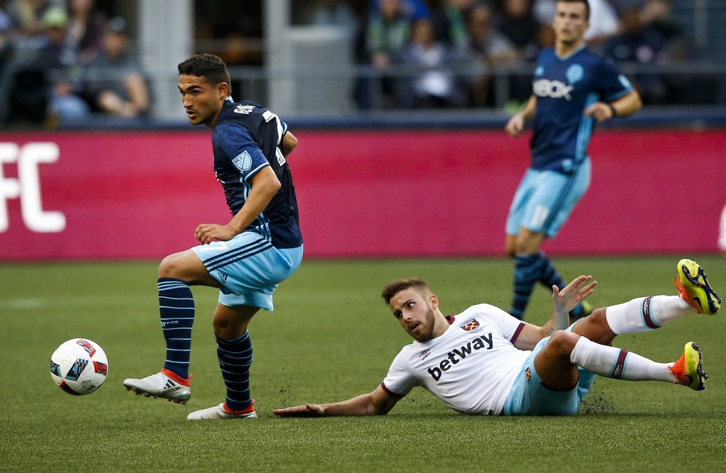 Seattle Sounders midfielder Cristian Roldan (left) gains control of the ball after a tackle on West Ham United&rsquo;s Diego Poyet during an international friendly match at CenturyLink Field in Seattle on Tuesday. (Ian Terry / The Herald)