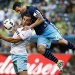 Sounders defender Zach Scott (right) battles for a header against West Ham United forward Andy Carroll during an international friendly Tuesday at CenturyLink Field in Seattle. (Ian Terry / The Herald)