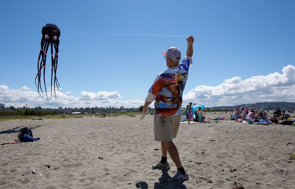 David Engle pulls on the string attached to his 24-foot octopus kite as he enjoys the winds of Jetty Island. (Andy Bronson / The Herald)