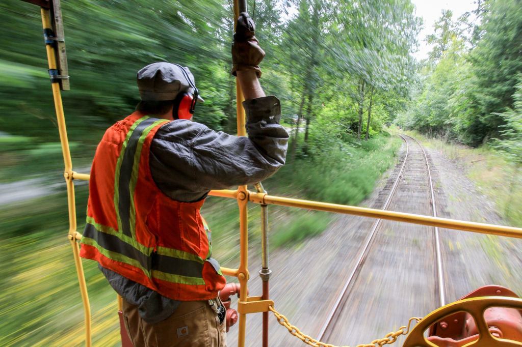 Nathan Proudfoot, conductor, mans the caboose during the weekly run from Woodinville to Snohomish Thursday on July 7. (Kevin Clark / The Herald)