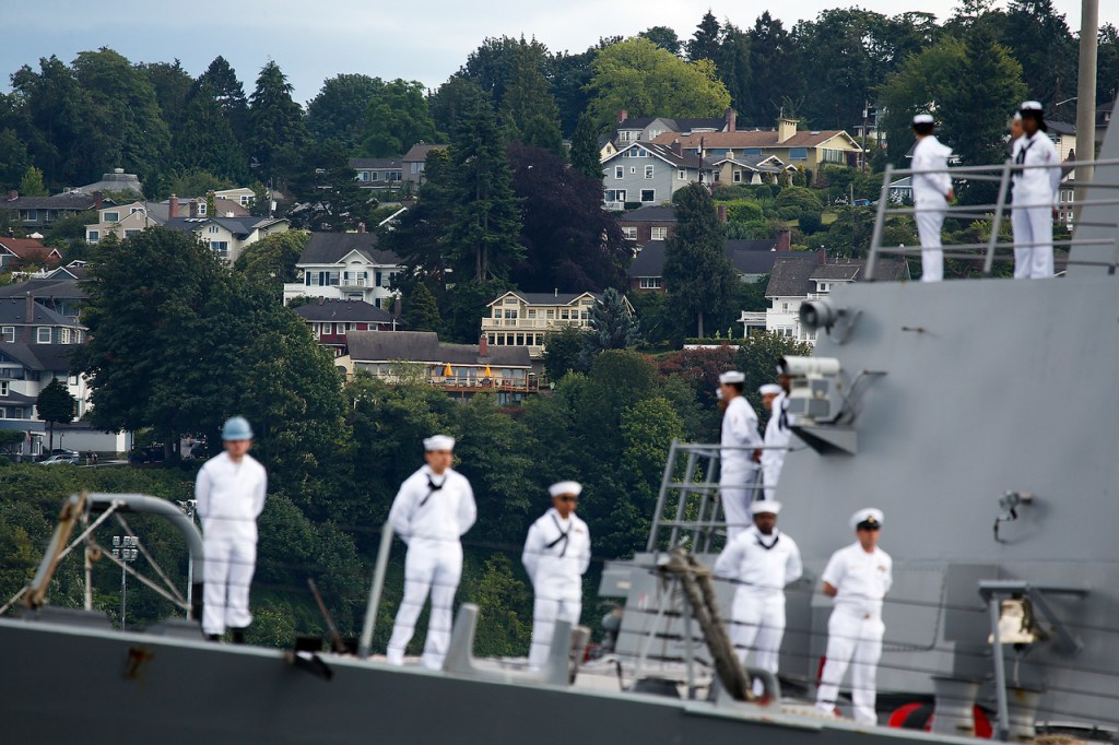 Navy sailors stand aboard the USS Gridley destroyer ship as she enters Naval Station Everett on Saturday. (Ian Terry / The Herald)