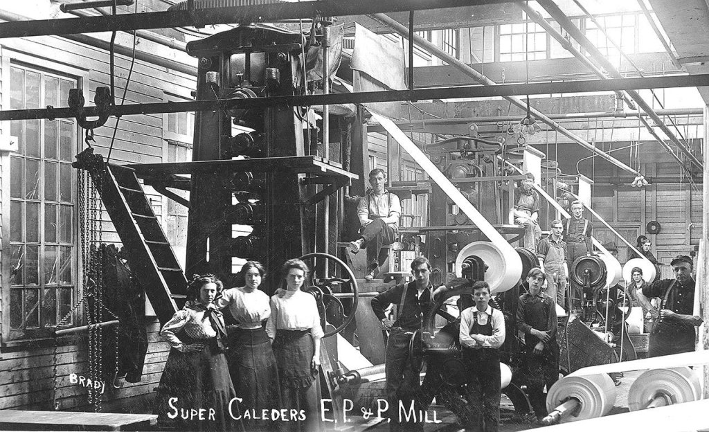 Women and boys pause during a work day at the Everett Pulp and Paper Mill in 1915 in Lowell. (Northwest History Room / Everett Public Library)