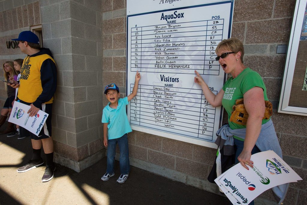 Alex and his mother Andrea Carroll, of Lynnwood point at game lineup that includes Seattle Mariner&rsquo;s Felix Hernandez before the Everett AquaSox take on Spokane at Everett Memorial Stadium on Sunday, July 10, 2016 in Everett, Wa. Hernandez was pitching as part of an injury rehabilitation program. (Andy Bronson / The Herald )