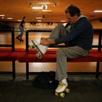 John Walker, of Seattle, laces up his skates before taking to the floor at a public session at Lynnwood Bowl and Skate on Thursday. Walker has been skating at the rink since 1964. (Ian Terry / The Herald)