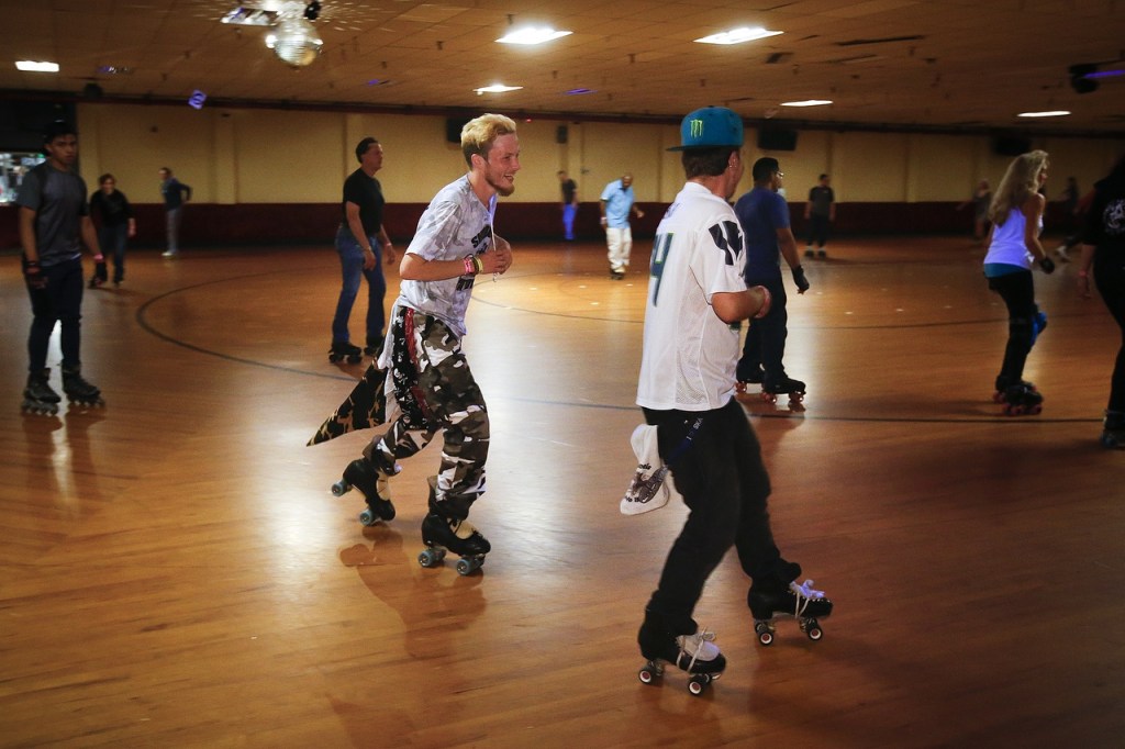 Michael Cameron (center left), of Bellevue, laughs with Sam Nelson, of Snohomish, as they skate a few laps to cool down from practicing their skate dance moves at Lynnwood Bowl and Skate on Thursday. (Ian Terry / The Herald)