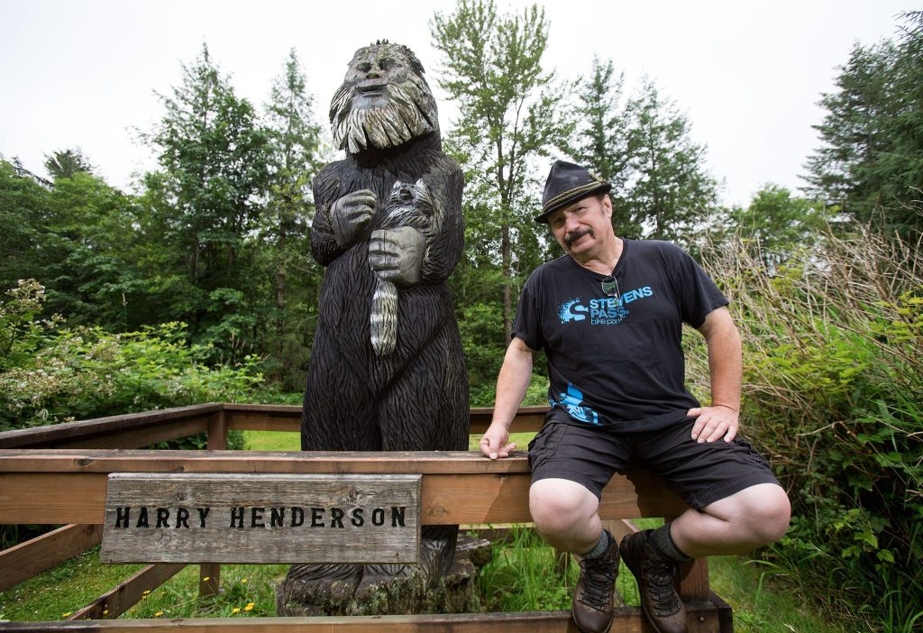 Mark Klein sits on a fence guarding the original Bigfoot statue near the Espresso Chalet. (Andy Bronson / The Herald)