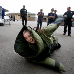 Marcus Nunez, 14, struggles to get to his feet while wearing an 80-pound bomb squad suit during the annual Everett Police Department Junior Police Academy at Eisenhower Middle School on Wednesday. (Andy Bronson / The Herald)